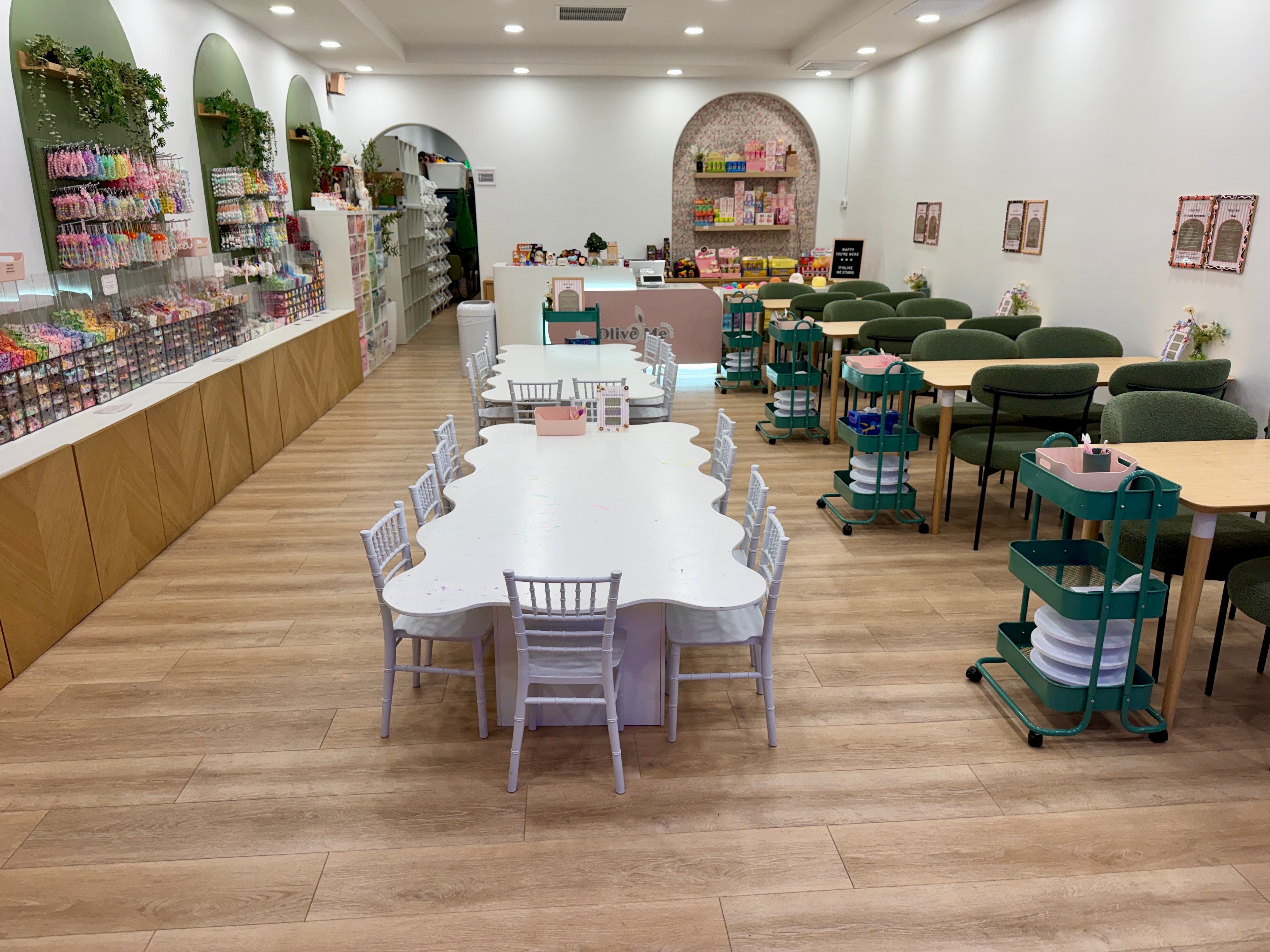 Inside Olive Me Studio showing the crafting tables, charm displays, and welcoming space